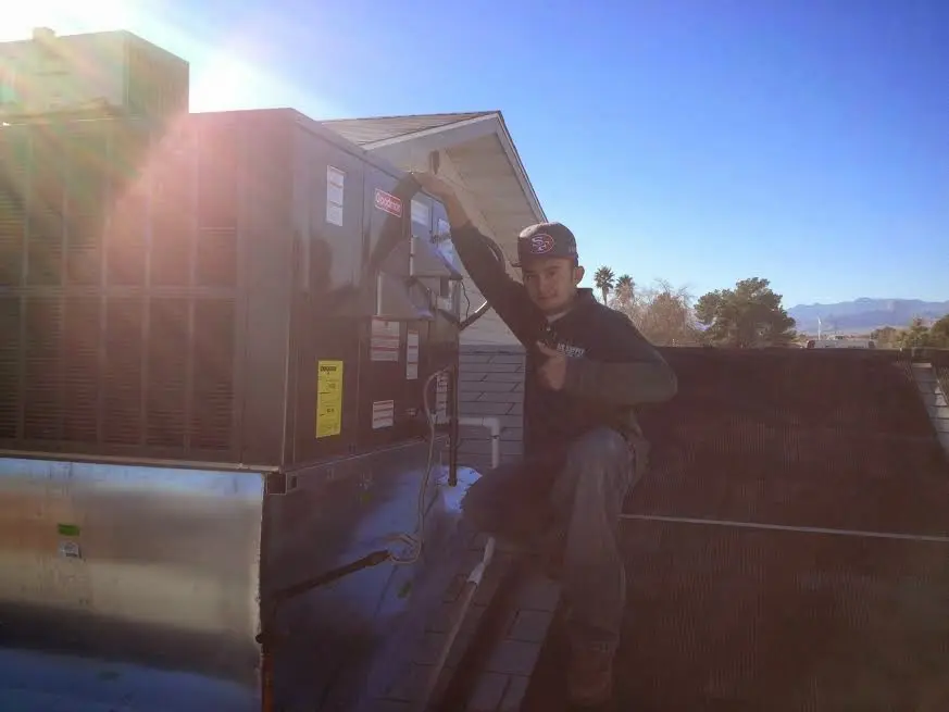 HVAC technician performing Heat Pump Repair on a rooftop unit in Carl Junction